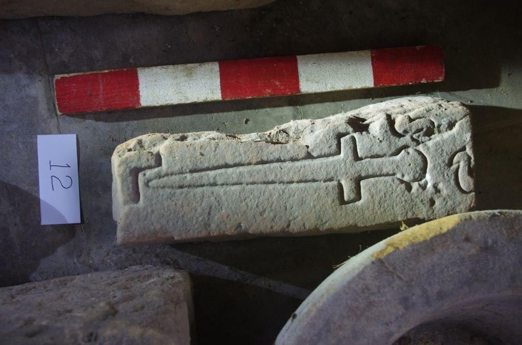 A fragment of a Medieval cross slab carved with a small sword 